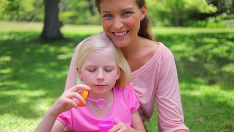 Niña-Soplando-Burbujas-Con-Su-Madre-