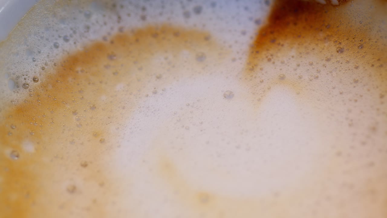 Macro of cappuccino textures, showing foam and milk swirls in Italy's café culture