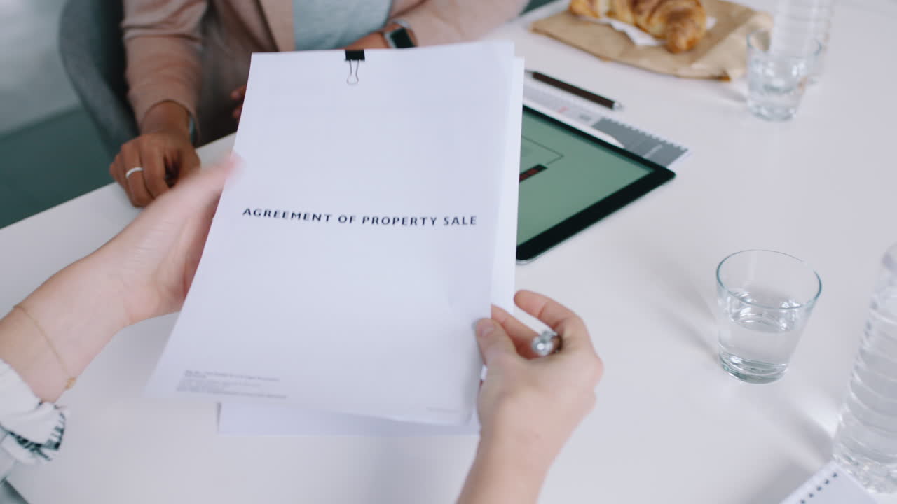 Profesionales de negocios firmando un acuerdo de compraventa de propiedad y dándose la mano