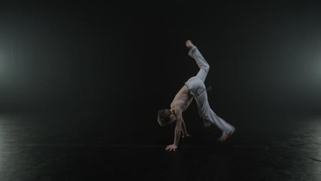 luchadores de capoeira realizando movimientos dinámicos en el escenario. artes marciales, danza y acrobacias en acción. atletas de pecho desnudo mostrando fuerza, flexibilidad y técnica bajo los reflectores