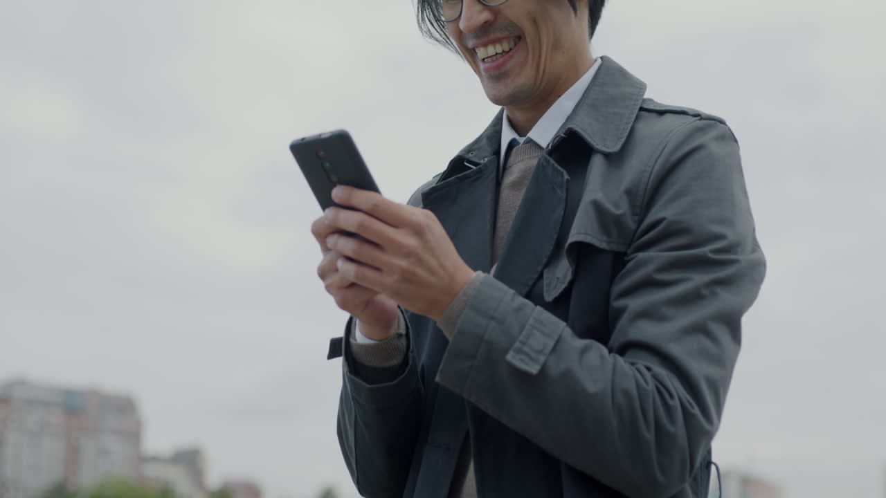 다리에서 스마트폰을 사용하는 사업가