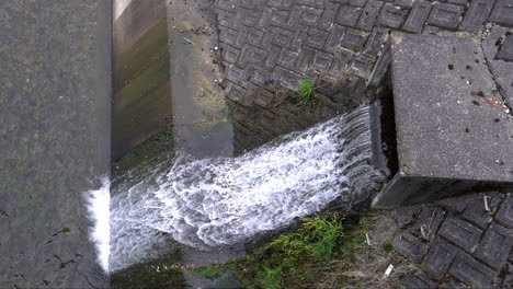 waste water flows out from the sewer pipe into the river