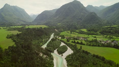 aerial view of a small village with typical houses next to soca river, slovenia.