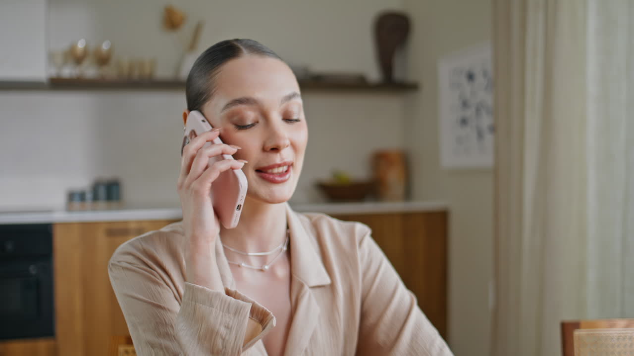 Joyful lady calling cellphone at kitchen closeup. Smiling woman talking phone