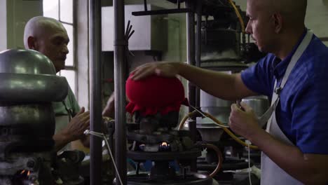 mixed race man working at a hat factory