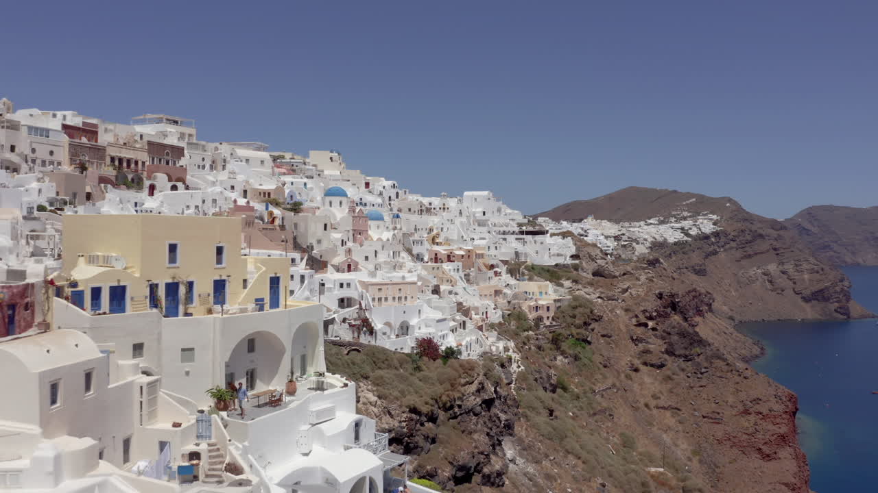 antena: drone vuela a baja altura en oia de santorini, grecia cerca de los hoteles