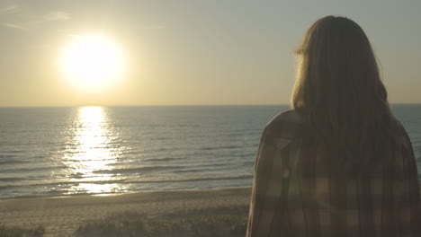 handheld shot of a woman looking out to the sunset.  shot in 4k