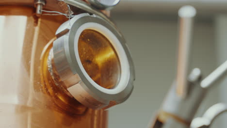 distilled alcohol inside a copper tank, industrial process in a gin distillery production