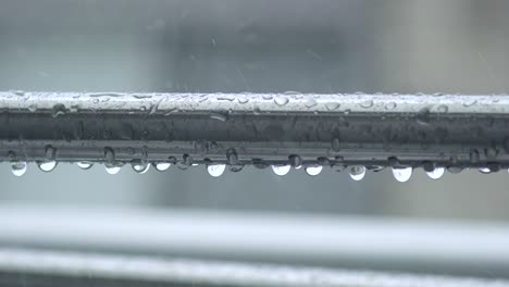 Primer-Plano-De-Un-Poste-De-Lavandería-En-El-Balcón-Con-Gotas-De-Lluvia-Durante-Un-Día-Lluvioso-En-Tokio,-Japón