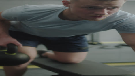 man training with kettlebell on gym bench