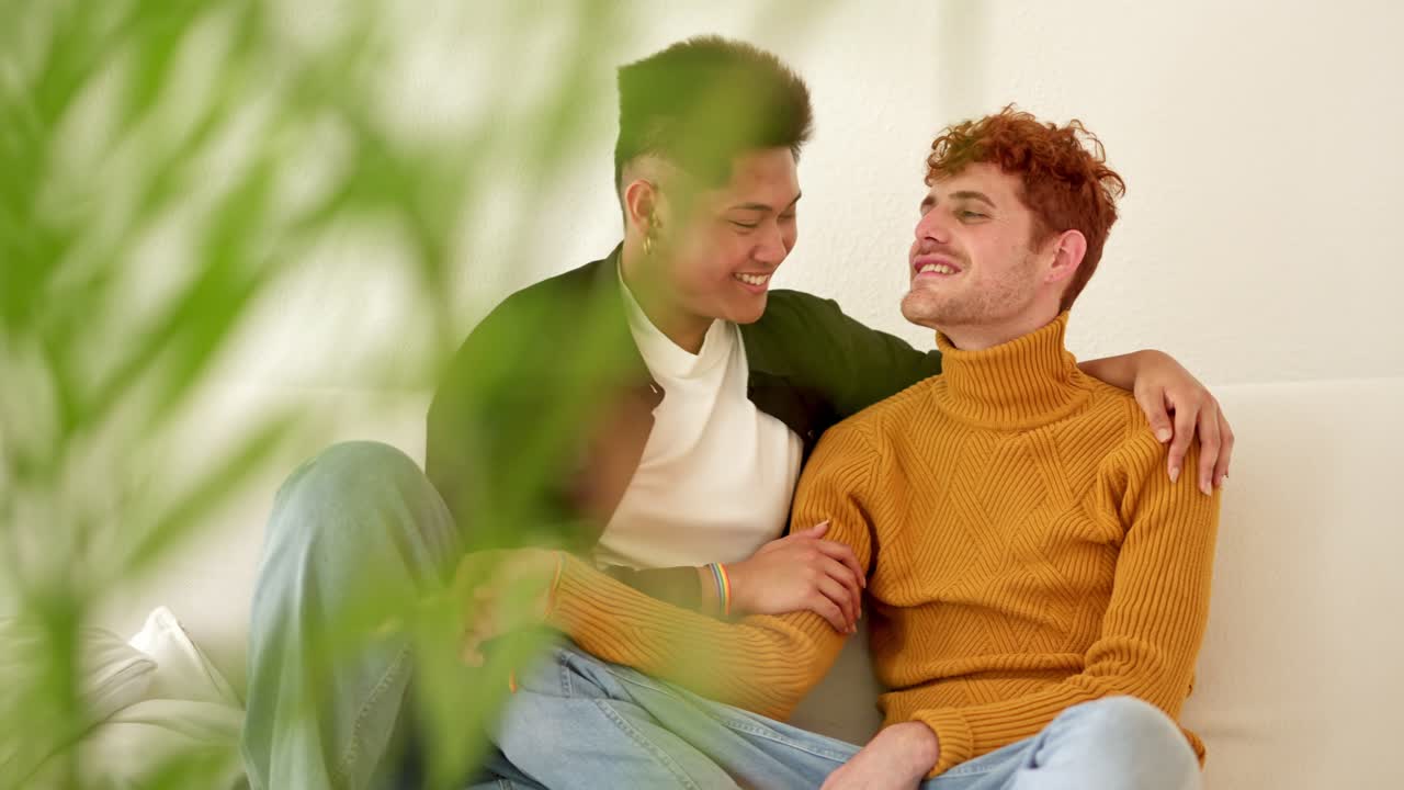Happy Gay Couple Embracing on a Sofa