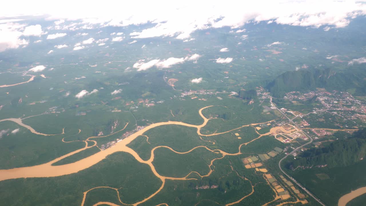 una vista de la ventana del avión superior mientras flota en el aire, con vistas a las montañas y los recursos naturales de agua a lo largo de la costa de tailandia