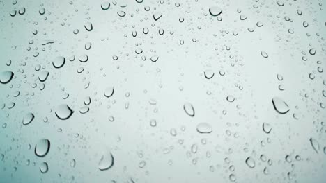 regenwaterdruppels vallen op het vensterglas, regendruppels op het venstersglas, macro shot van waterdruppels vallen. zachte focus. oppervlakkig focus effect.