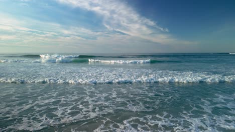 Olas-Acercándose-A-La-Orilla-Con-Cielo-Azul-De-Fondo-En-Caion,-Galicia,-España