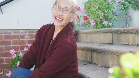 portrait of happy asian senior woman on sunny day in garden