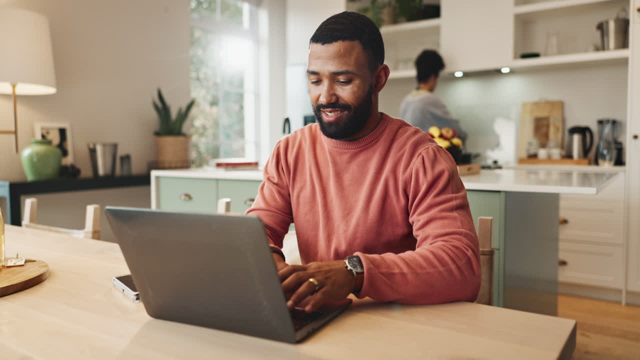 hombre trabajando en una computadora portátil en casa