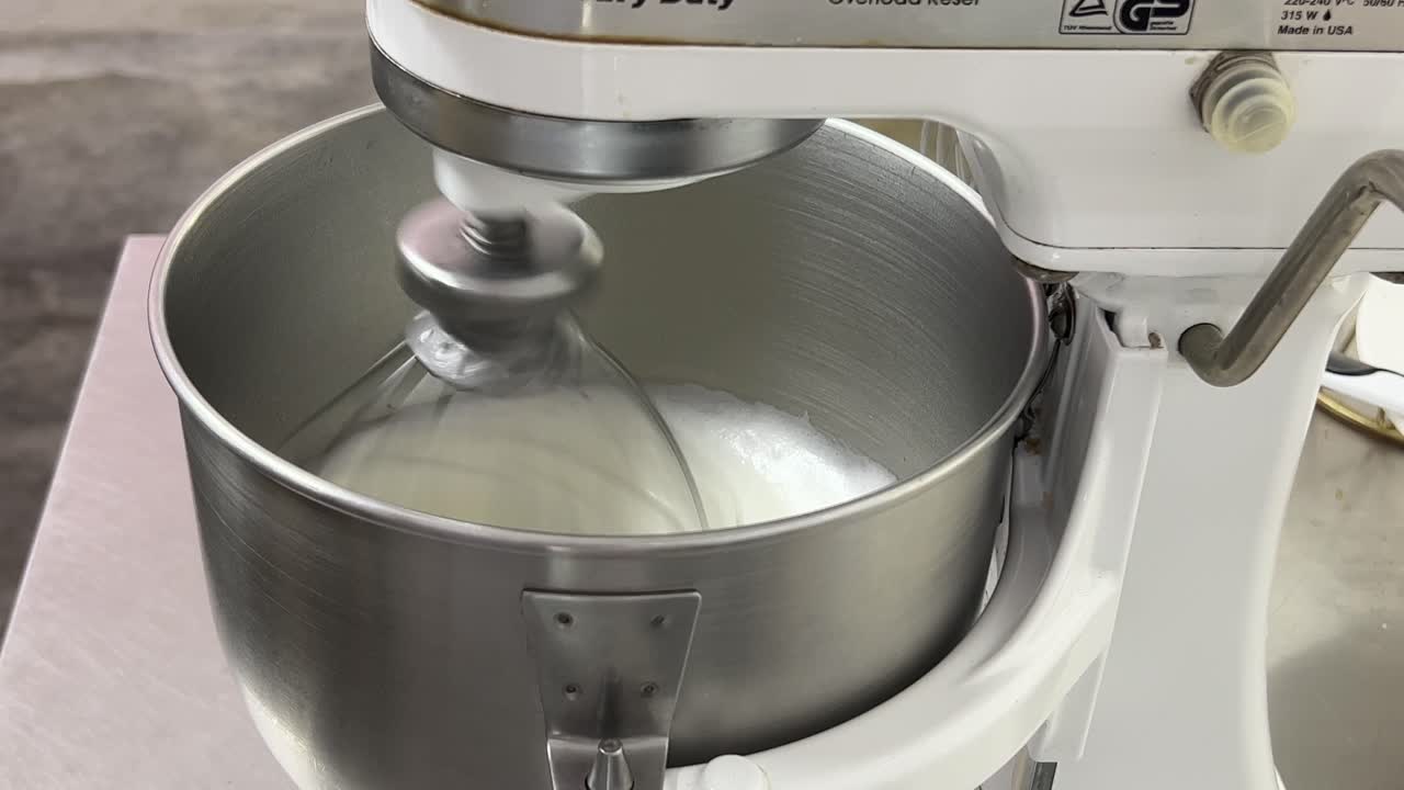 preparación de pastelería de crema de mantequilla de merengue suizo esponjoso y suave, batidora eléctrica mezclando y batiendo la clara de huevo y el azúcar hasta que esté brillante y rígido