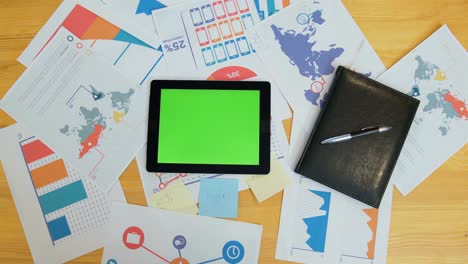 hombre usando una tableta con pantalla verde en el escritorio de la oficina, espacio de trabajo, búsqueda de información