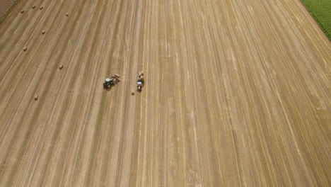 aerial birdseye view above farming tractors in preparation cultivation of harvest wheat fields