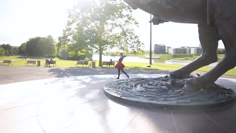 Amazing-female-dancer-dancing-outside-in-a-summer-next-to-a-statue