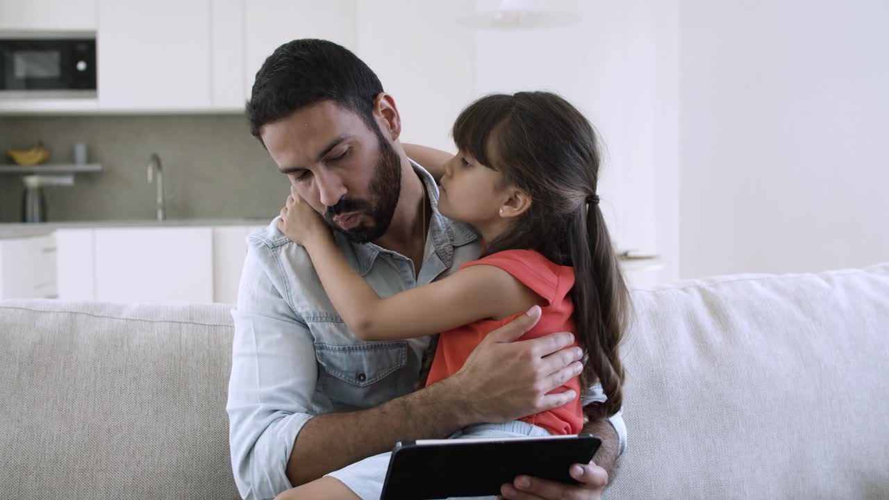 padre feliz sosteniendo a su hija en el regazo