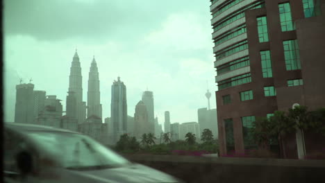 kuala lumpur cityscape revealed as seen from inside the metro, rainy outside, raindrops on outside window commuter