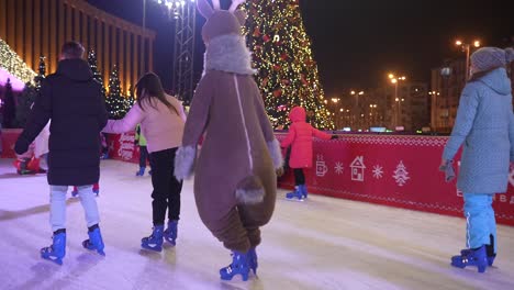 christmas ice skating rink at night with reindeer costume