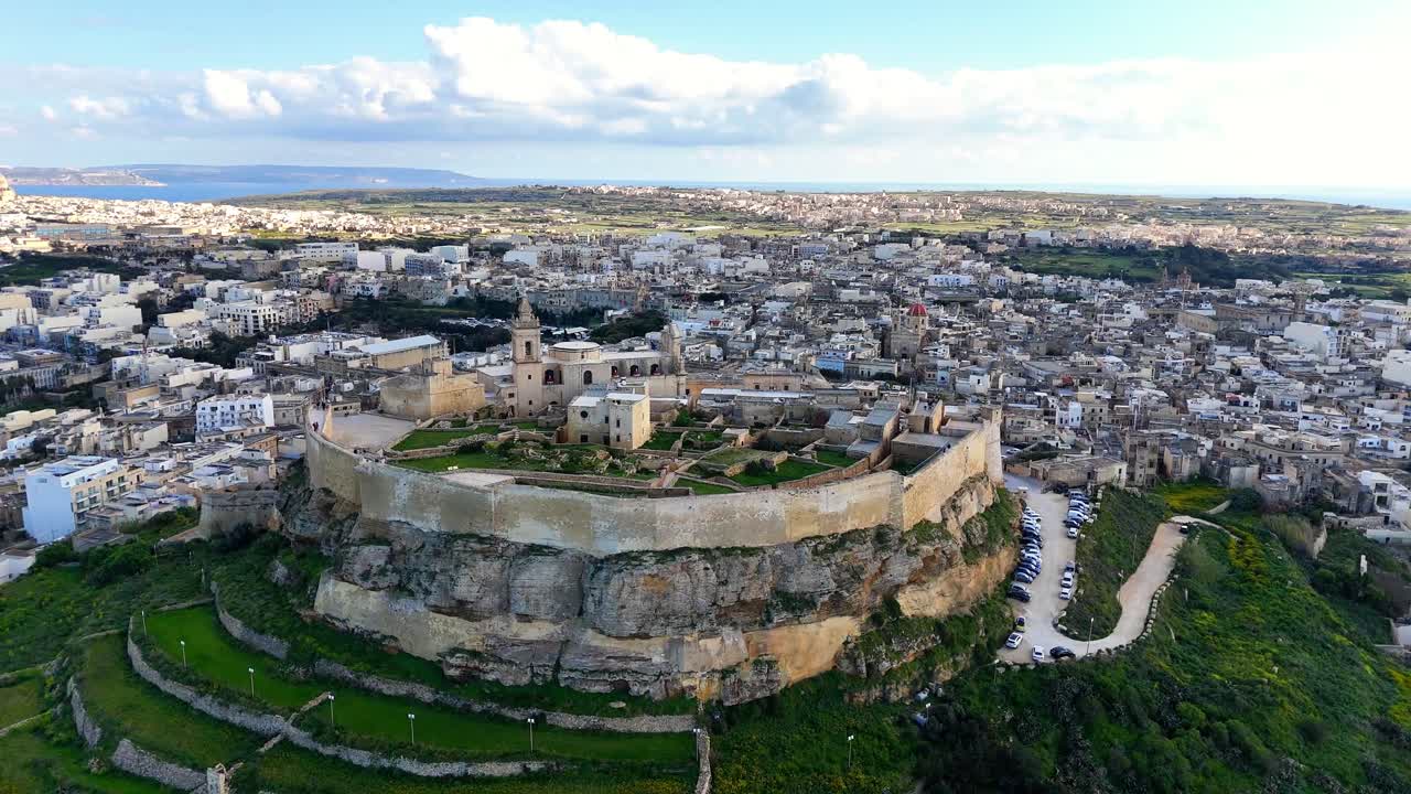 La Cittadella Il-Kastell en Victoria Rabat Gozo Malta revela bastiones fortificados y la Catedral de la Asunción sobre una colina de piedra caliza con vistas a un denso paisaje urbano y una meseta central, toma orbital