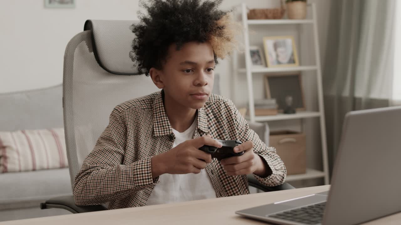 niño jugando a un juego de computadora con un controlador