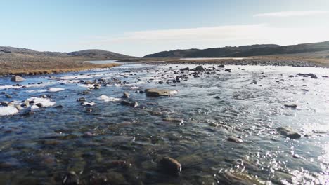 río parcialmente congelado en la tundra canadiense