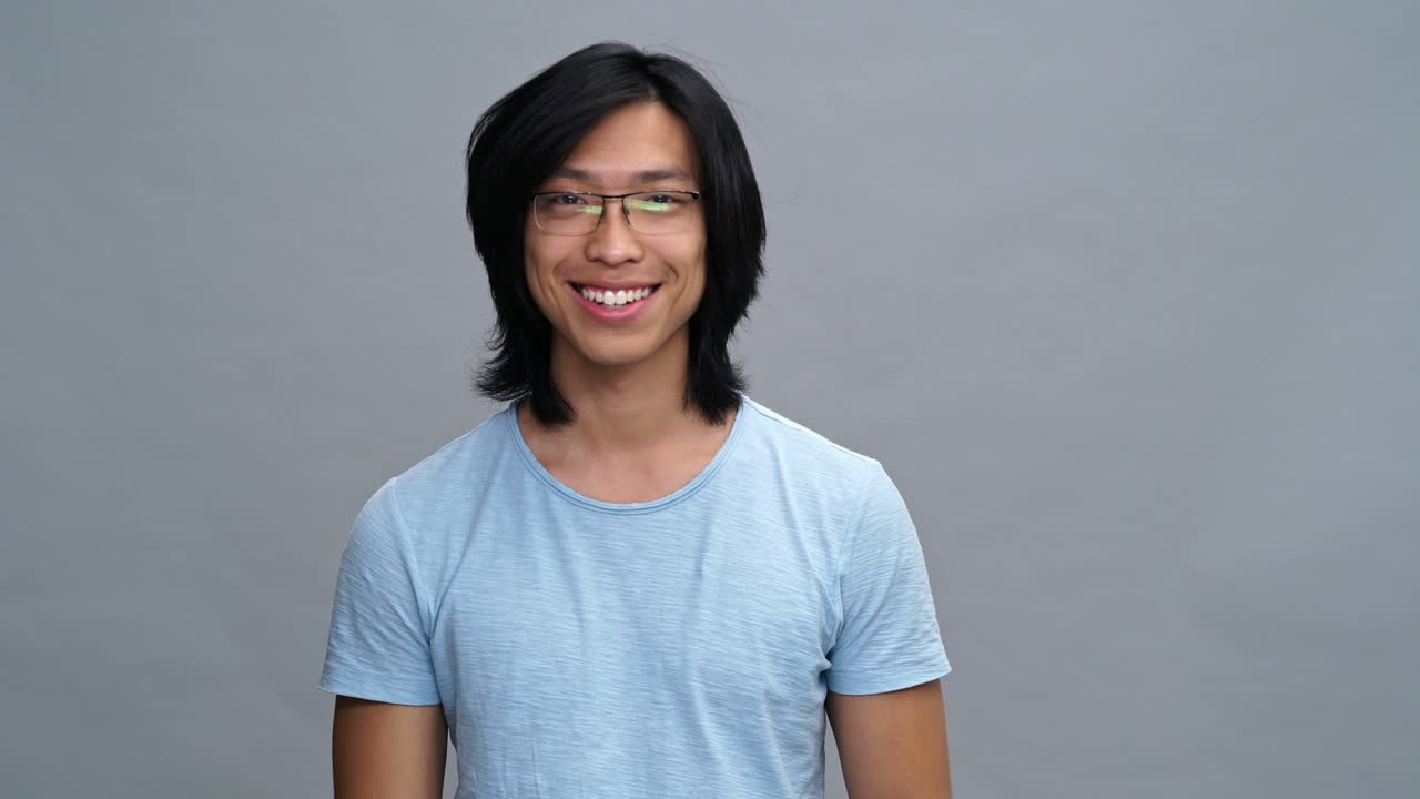 예쁜 행복한 젊은 아시아 남자가 신용카드를 보여줍니다.