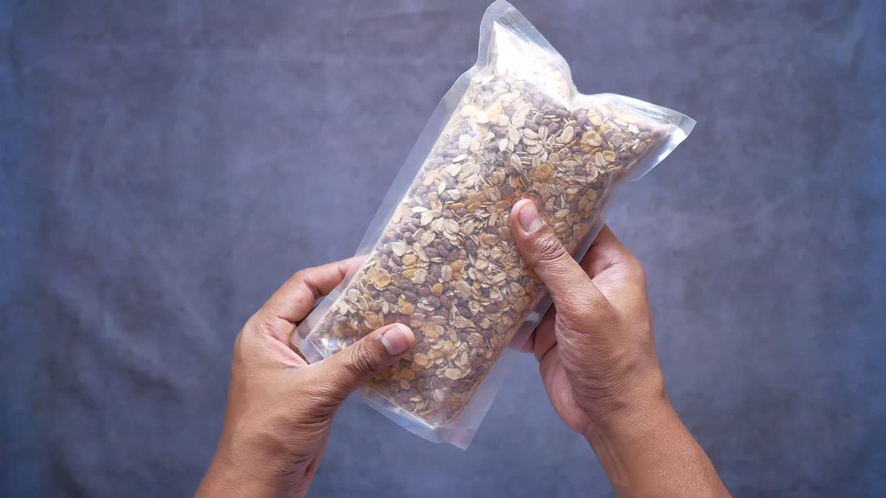 persona que sostiene una bolsa de granola de avena