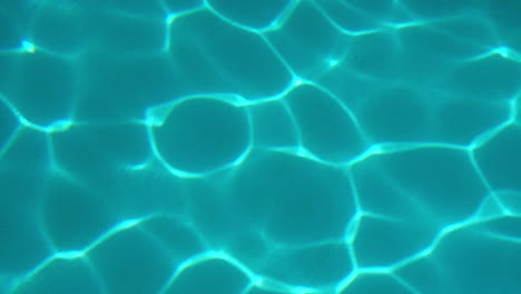 refracted light patterns on bottom of swimming pool