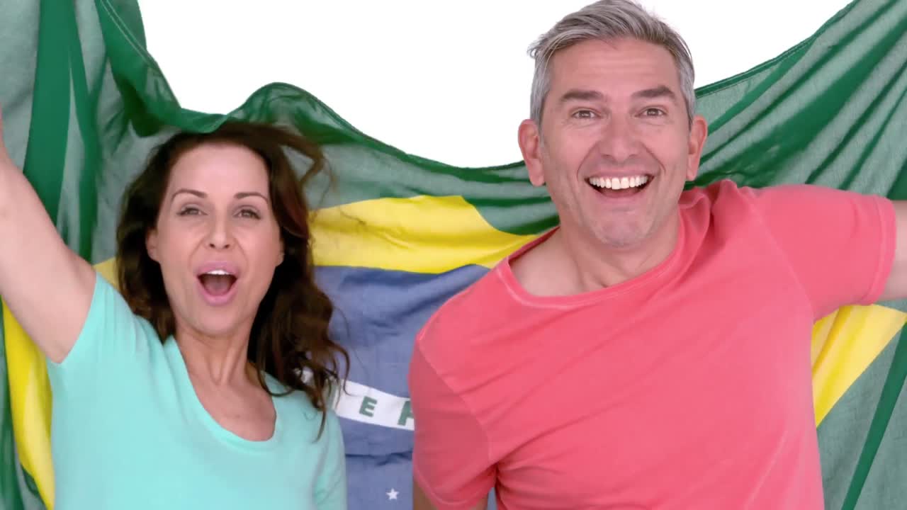 una pareja de aficionados al fútbol con la bandera de brasil