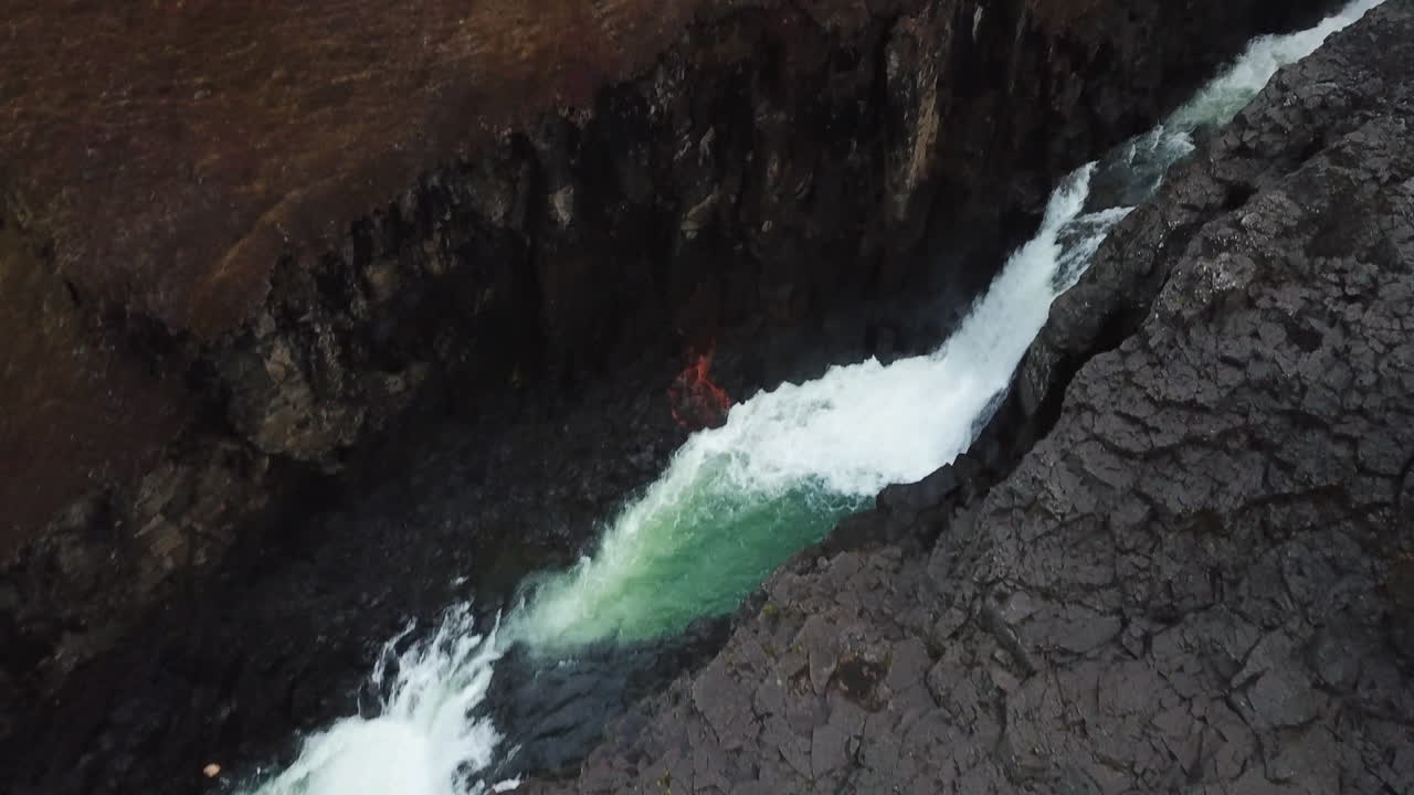 Islands magiske naturskønhed: Gletsjerflod og vandfald i basaltsøjlekløften Studlagil, luftfoto fra fugleperspektiv