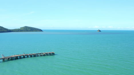 4K-Aerial-Drone-Over-Long-Jetty-Wharf-Over-Blue-Pacific-Ocean-In-Cairns,-North-Queensland,-Australia