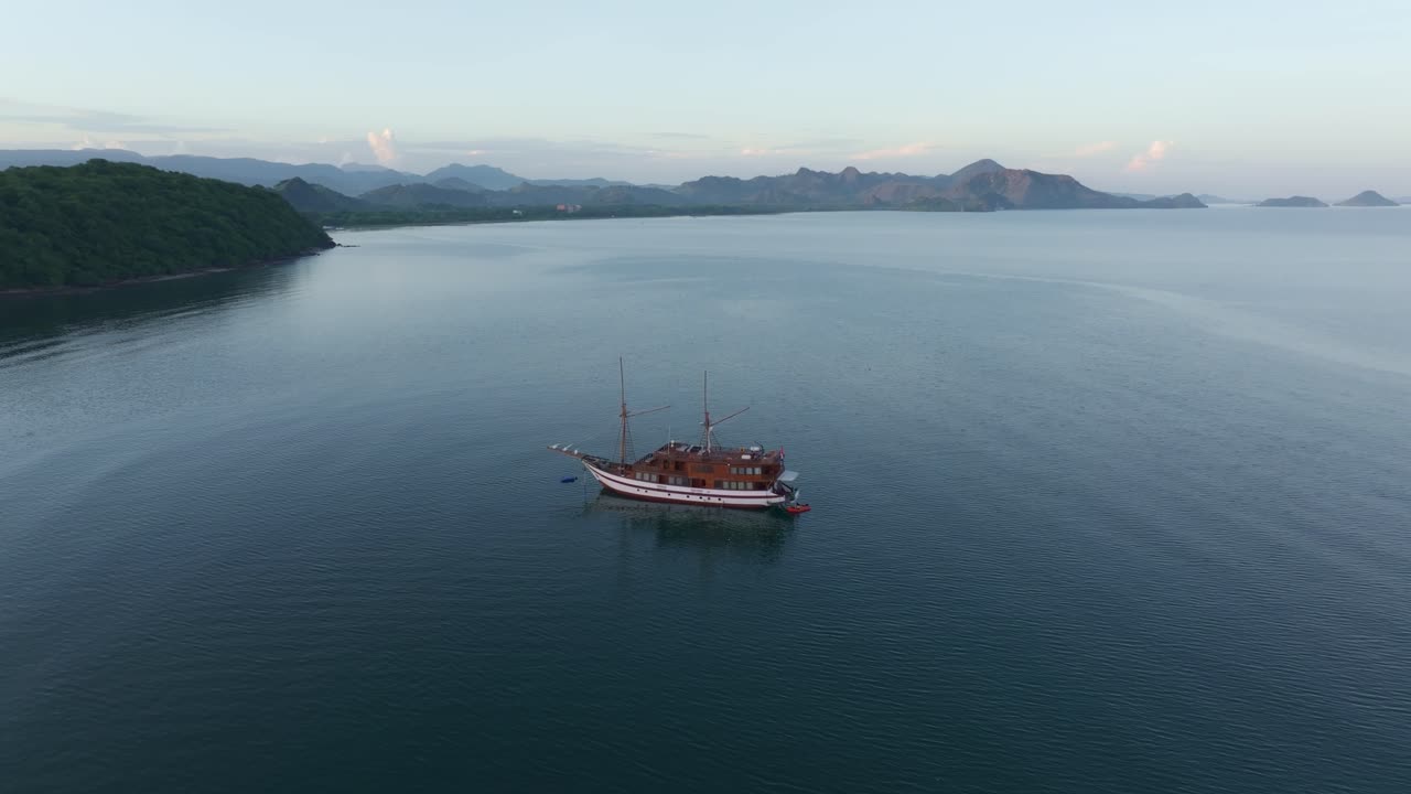 Perahu pengunjung tertambat di teluk yang tenang, Labuan Bajo, Flores, Indonesia