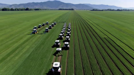 autonomous tractors tilling a large green field