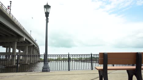 Scenic-Bench-at-Iconic-Bridge-over-Majestic-River-Surrounded-by-Dramatic-Sky