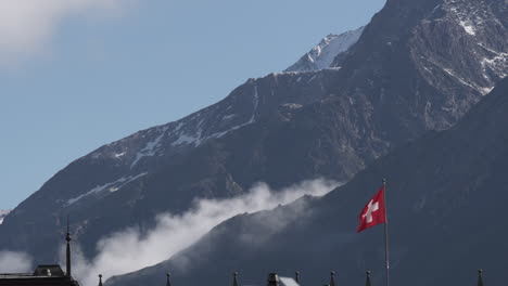 Bandera-Suiza-Con-Paisaje-De-Montaña-Como-Telón-De-Fondo