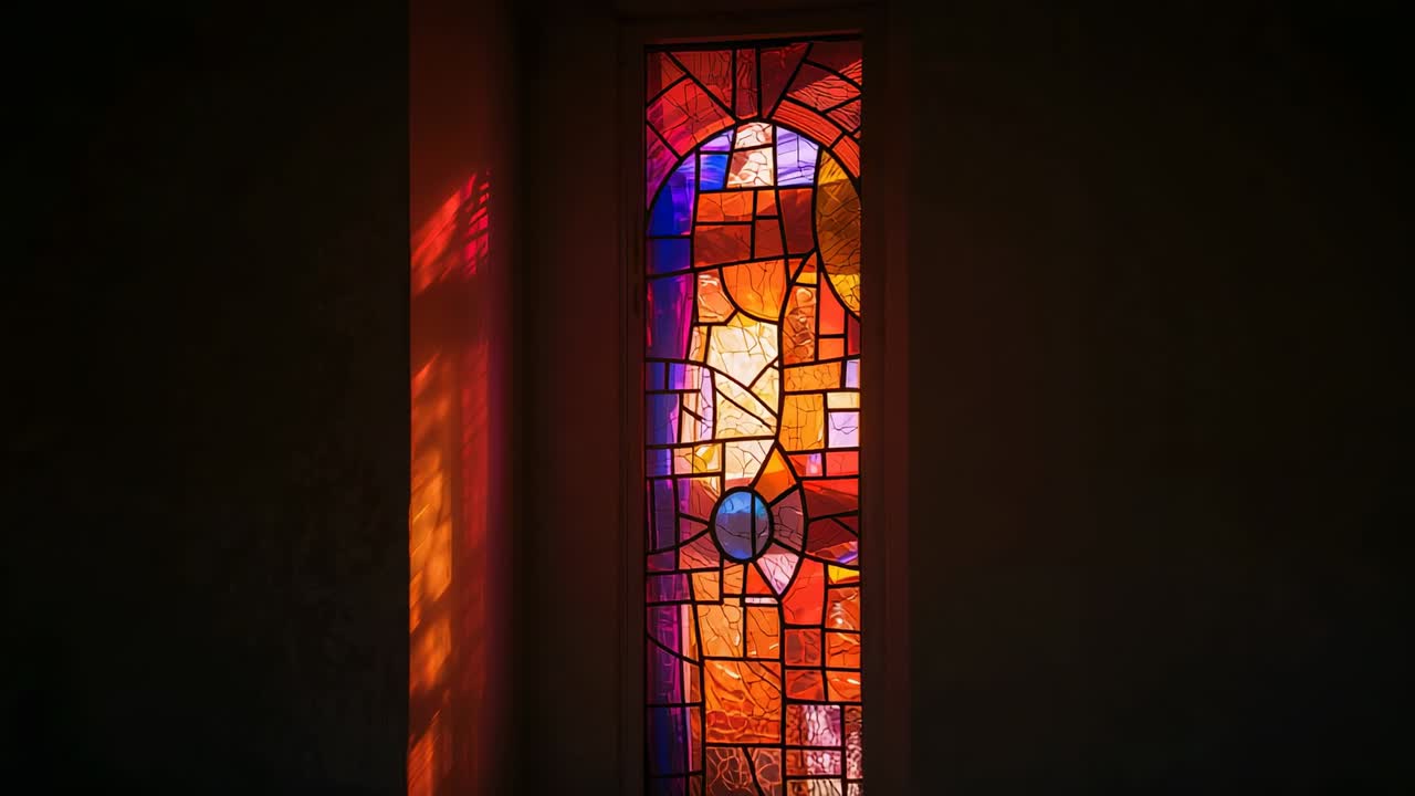Stained glass window filtering sun in dark room, casting amber reflections onto plaster wall