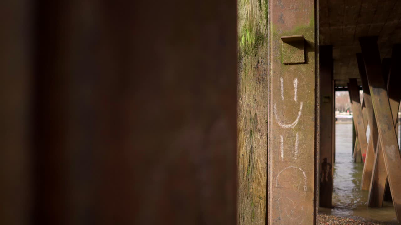 emojis felices y tristes dibujados en un muelle de metal junto al río támesis en londres, estado de ánimo bipolar, en cámara lenta