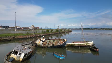 Six-shipwrecks-in-calm-water-near-dockside-on-River-Wyre-at-Fleetwood-Docks-Lancashire-UK