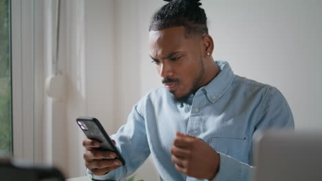 Chico-Molesto-Usando-Un-Teléfono-Móvil-En-El-Piso.-Hombre-Irritado-Mirando-La-Pantalla-Del-Teléfono-Inteligente