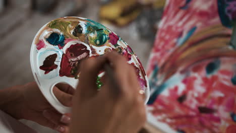 person holding palette with several colors