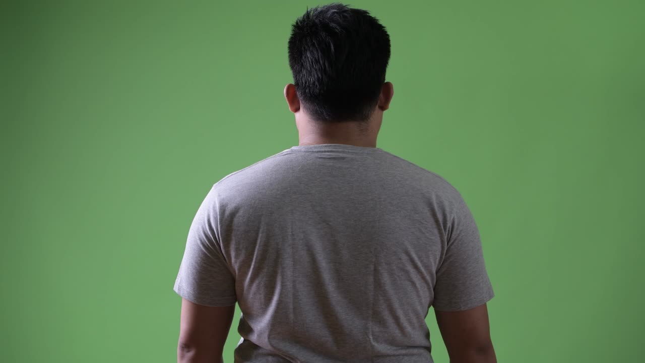 초록색 배경에 젊은 잘생긴 과체중 아시아인