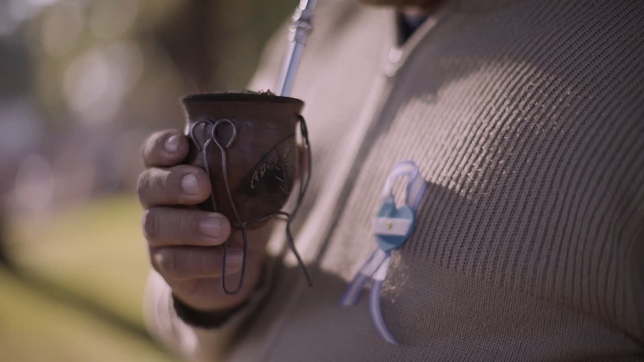 Argentine man holding traditional mate with national cockade on patriotic celebration day