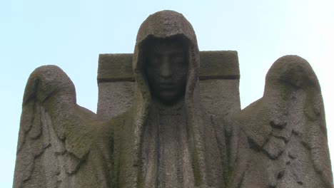 a ghostly angel looks down on a grave from above 1