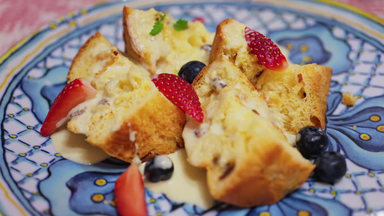 Close up of multiple pieces of panettone with condensed milk and berries on top
