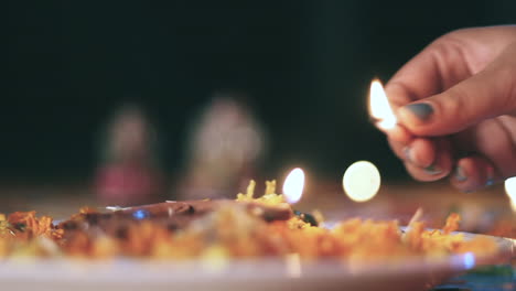 chica iluminando el diya para diwali pooja